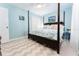 Bright bedroom features a four-poster bed, ceiling fan and an ensuite bathroom at 909 Silver Palm Way, Apollo Beach, FL 33572