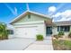 A well-maintained home with a two-car garage, a blue door, and tasteful landscaping at 909 Silver Palm Way, Apollo Beach, FL 33572