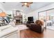 Cozy living room featuring a stone fireplace, a ceiling fan, dark floors, and seating areas at 909 Silver Palm Way, Apollo Beach, FL 33572