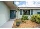 Inviting front entrance with a charming blue door, potted plants, and decorative details at 909 Silver Palm Way, Apollo Beach, FL 33572