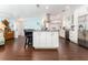 Bright kitchen featuring granite countertops, an island, stainless steel appliances, and dark wood-look floors at 909 Silver Palm Way, Apollo Beach, FL 33572