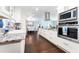Modern kitchen featuring granite countertops, white cabinets, stainless steel appliances, and a view into the dining room at 909 Silver Palm Way, Apollo Beach, FL 33572
