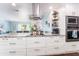Bright kitchen featuring granite countertops, a cooktop, an island, and stainless steel appliances at 909 Silver Palm Way, Apollo Beach, FL 33572