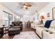 Large living room with dark floors, tan leather furniture, a stone fireplace, and views to other rooms at 909 Silver Palm Way, Apollo Beach, FL 33572