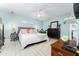 Inviting main bedroom with tranquil blue walls, ceiling fan, and hardwood floors for a peaceful and stylish space at 909 Silver Palm Way, Apollo Beach, FL 33572