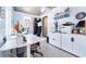 Well-lit home office featuring a white desk, ample storage, and a comfortable chair, perfect for remote work at 909 Silver Palm Way, Apollo Beach, FL 33572