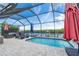 Sparkling screened-in pool offers stunning backyard and water views at 909 Silver Palm Way, Apollo Beach, FL 33572