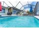 Relaxing screened-in pool area with a covered patio, lounge chairs, and lush greenery at 909 Silver Palm Way, Apollo Beach, FL 33572