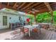 A backyard with a covered dining area, outdoor kitchen, hot tub, and lush green landscaping at 1042 S Sterling Ave, Tampa, FL 33629