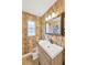Bathroom featuring a vanity with storage, wallpaper, and decorative mirror at 1042 S Sterling Ave, Tampa, FL 33629