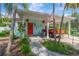 The home features a welcoming front porch with rocking chairs, a vibrant red door, and quaint decor at 1042 S Sterling Ave, Tampa, FL 33629