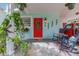 Inviting front porch with a bright red door, rocking chairs, and decorative plants creating a cozy entrance at 1042 S Sterling Ave, Tampa, FL 33629