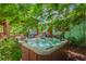 A hot tub surrounded by lush landscaping and greenery, with views of an outdoor kitchen and covered patio at 1042 S Sterling Ave, Tampa, FL 33629