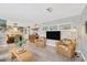 Bright living room showcasing wicker seating, terrazzo flooring, and view into dining area at 1042 S Sterling Ave, Tampa, FL 33629