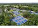An aerial view of community tennis and pickleball courts with mature trees throughout at 1358 Forestedge Blvd, Oldsmar, FL 34677