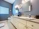 Bathroom with double vanity featuring granite countertop and white cabinets at 1358 Forestedge Blvd, Oldsmar, FL 34677