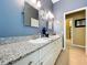 Bathroom with double vanity featuring granite countertop and white cabinets at 1358 Forestedge Blvd, Oldsmar, FL 34677