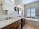 Bathroom featuring double sink vanity with granite countertop, tub, and tile floor at 1358 Forestedge Blvd, Oldsmar, FL 34677