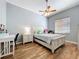 Bright bedroom with wood-look tile flooring, ceiling fan, and white furniture, creating a cozy space at 1358 Forestedge Blvd, Oldsmar, FL 34677