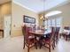 Inviting dining room with a wooden table, complemented by tile flooring and a decorative chandelier at 1358 Forestedge Blvd, Oldsmar, FL 34677