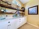 Hallway with custom shelving and white cabinetry for ample storage at 1358 Forestedge Blvd, Oldsmar, FL 34677