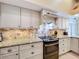 Stylish kitchen showcases granite counters, tile backsplash, modern cabinetry, and stainless steel appliances at 1358 Forestedge Blvd, Oldsmar, FL 34677