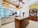 Bright kitchen featuring an island, granite countertops, and stainless steel appliances with views to the living room at 1358 Forestedge Blvd, Oldsmar, FL 34677