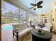 Inviting screened-in lanai with ample seating, ceiling fans, and views of the pool and backyard at 1358 Forestedge Blvd, Oldsmar, FL 34677