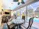 Enclosed lanai includes a dining table set and seating area with views of the screened-in pool at 1358 Forestedge Blvd, Oldsmar, FL 34677