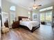 Bright, spacious main bedroom featuring wood floors, fan, and access to lanai at 1358 Forestedge Blvd, Oldsmar, FL 34677