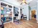 Home office with ceiling fan, custom built-in shelving and wood-look tile flooring at 1358 Forestedge Blvd, Oldsmar, FL 34677