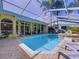 Screened pool with attached spa surrounded by brick pavers, lounge chairs, and a basketball hoop at 1358 Forestedge Blvd, Oldsmar, FL 34677