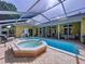Screened pool with hot tub, outdoor lounge area, and covered lanai provide a relaxing backyard retreat at 1358 Forestedge Blvd, Oldsmar, FL 34677