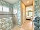 Full bathroom showcasing shower, decorative wallpaper, and linen storage at 16413 Rivers Reach Blvd, Parrish, FL 34219