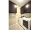 Functional laundry room featuring dark cabinets and modern, front-loading washer and dryer at 16413 Rivers Reach Blvd, Parrish, FL 34219