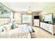 Bright main bedroom featuring calming colors, light wood floors, and white furniture set at 16413 Rivers Reach Blvd, Parrish, FL 34219