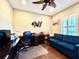 Inviting office space with dark wood floors, blue sofa, and ceiling fan at 16413 Rivers Reach Blvd, Parrish, FL 34219