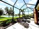 Covered patio features lounge chairs, grill, and picturesque lake view at 16413 Rivers Reach Blvd, Parrish, FL 34219