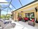 Covered patio with lounge chairs and dining set, overlooking a beautiful lake at 16413 Rivers Reach Blvd, Parrish, FL 34219