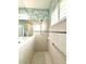Bathroom with a shower, decorative wallpaper and a tiled floor at 16413 Rivers Reach Blvd, Parrish, FL 34219