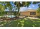 A lush backyard featuring a screened pool, mature trees, and well-maintained lawn surrounding the home at 18504 Putters Pl, Tampa, FL 33647