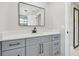 Modern bathroom vanity with grey cabinets, black hardware, and a large mirror at 18504 Putters Pl, Tampa, FL 33647