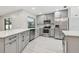 Modern kitchen with stainless steel appliances, gray cabinets, and white countertops at 18504 Putters Pl, Tampa, FL 33647