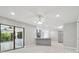 Open concept living space with light wood floors, modern lighting, and sliding glass doors to the outdoor patio at 18504 Putters Pl, Tampa, FL 33647