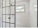 Stylish shower with black framed glass and modern fixtures, complemented by white tiled walls at 18504 Putters Pl, Tampa, FL 33647