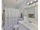 This bathroom features a shower with a curtain, a mirror, and a sink with a white countertop at 1905 Canterbury Ln # 17, Sun City Center, FL 33573