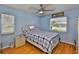 Bright blue bedroom with hardwood floors, ceiling fan, and window for natural light at 1905 Canterbury Ln # 17, Sun City Center, FL 33573