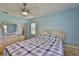 Light blue bedroom with ceiling fan, hardwood floors and mirror above the headboard at 1905 Canterbury Ln # 17, Sun City Center, FL 33573
