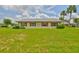 Charming home exterior features a large, well-maintained lawn and mature landscaping with red shutters on the windows at 1905 Canterbury Ln # 17, Sun City Center, FL 33573
