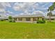 Charming home exterior features a large, well-maintained lawn and mature landscaping with red shutters on the windows at 1905 Canterbury Ln # 17, Sun City Center, FL 33573